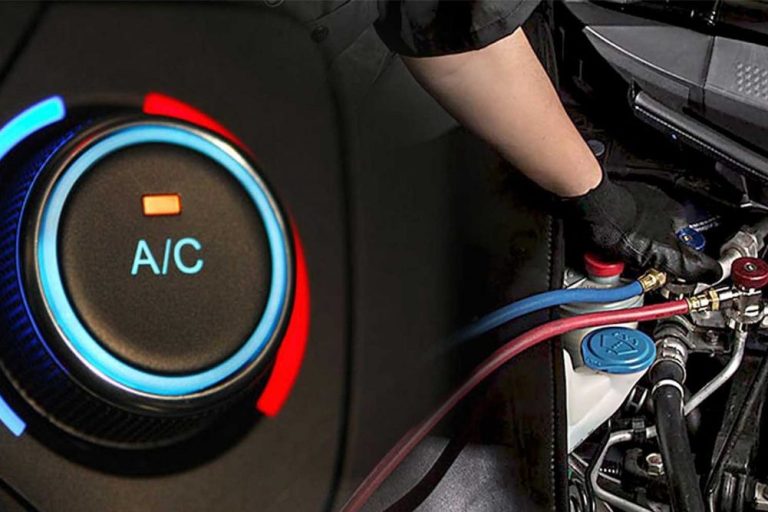 Close-up of an air conditioning dial with a technician working on car AC components.